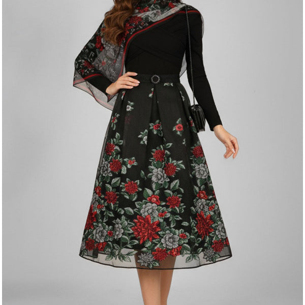 Woman wearing a black dress with floral patterns on a gray background