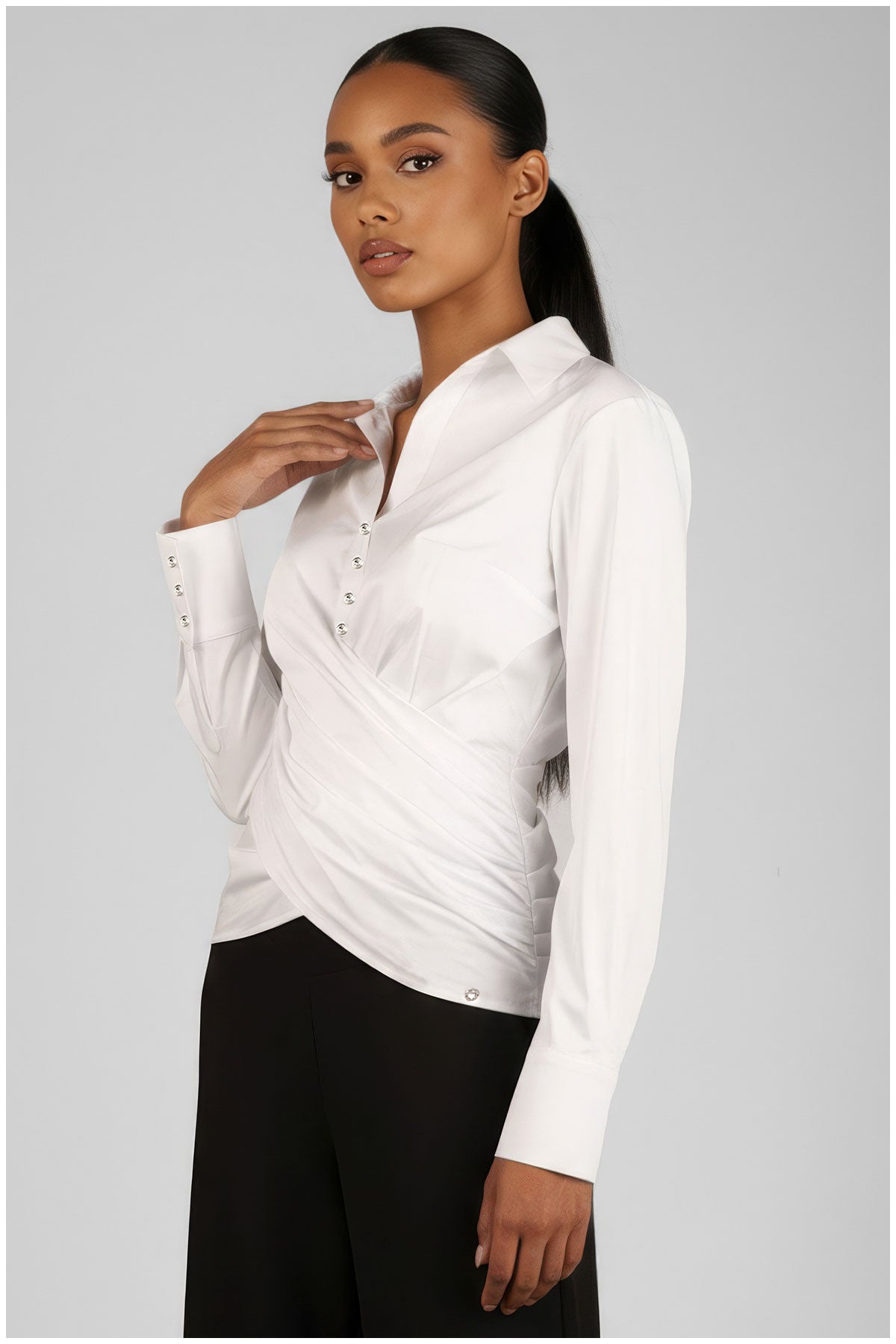 Woman wearing a white blouse with a subtle pattern on a gray background