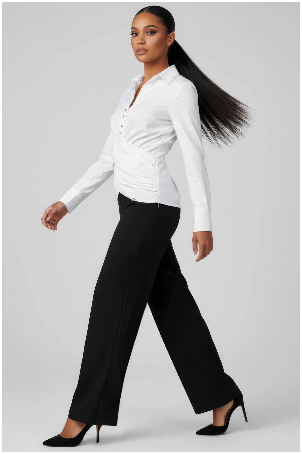 Woman wearing a white blouse and black pants on a gray background