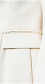 Close-up of a white pearl Luna Fashion House garment with metal trim on a white background