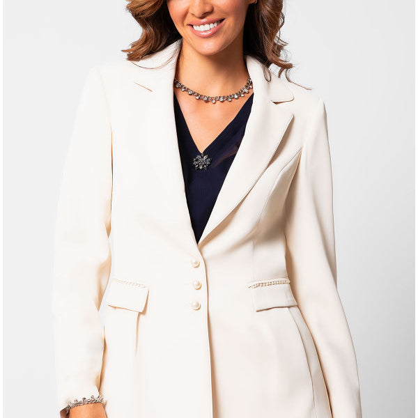 Woman wearing a white Luna Fashion House suit jacket and pants on a plain background