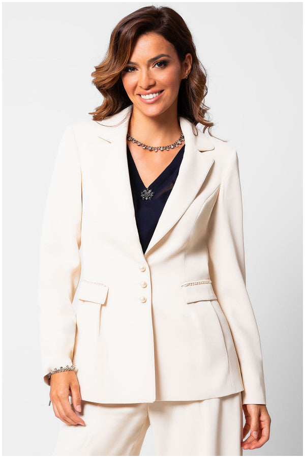 Woman wearing a white Luna Fashion House suit jacket and pants on a plain background