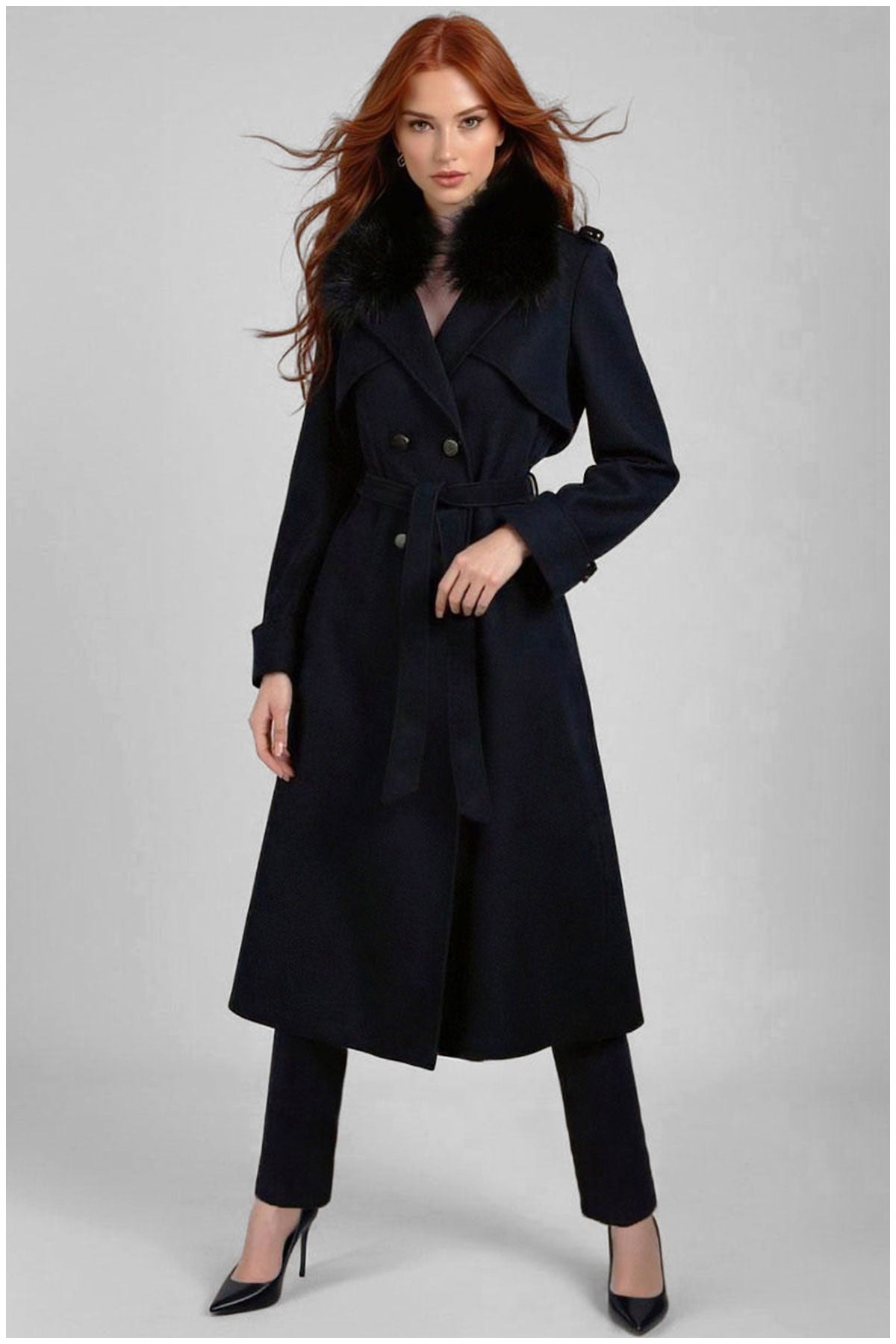 Woman wearing a navy blue coat on a gray background