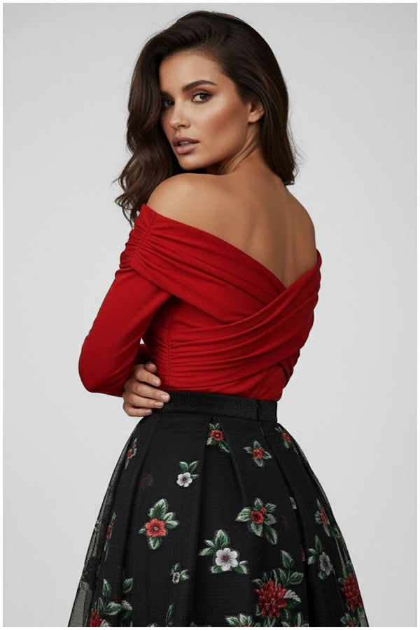 Woman wearing a red off-shoulder Luna Fashion House top and black floral skirt on a gray background
