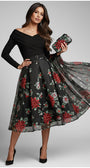 Woman wearing a black Luna Fashion House dress with floral pattern and holding a clutch.