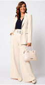 Woman in a beige Luna Fashion House  suit holding a matching handbag against a white background