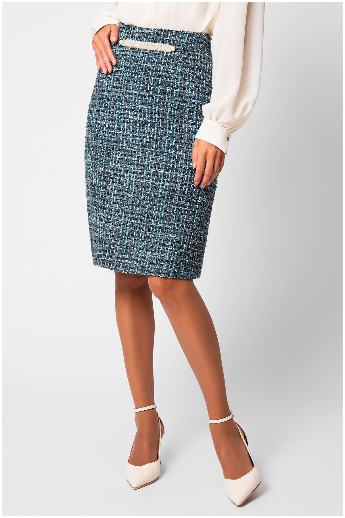 Person wearing a blue patterned skirt on a light gray background