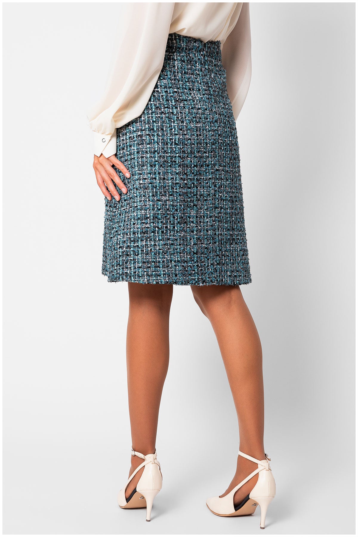 Person wearing a blue tweed skirt on a white background