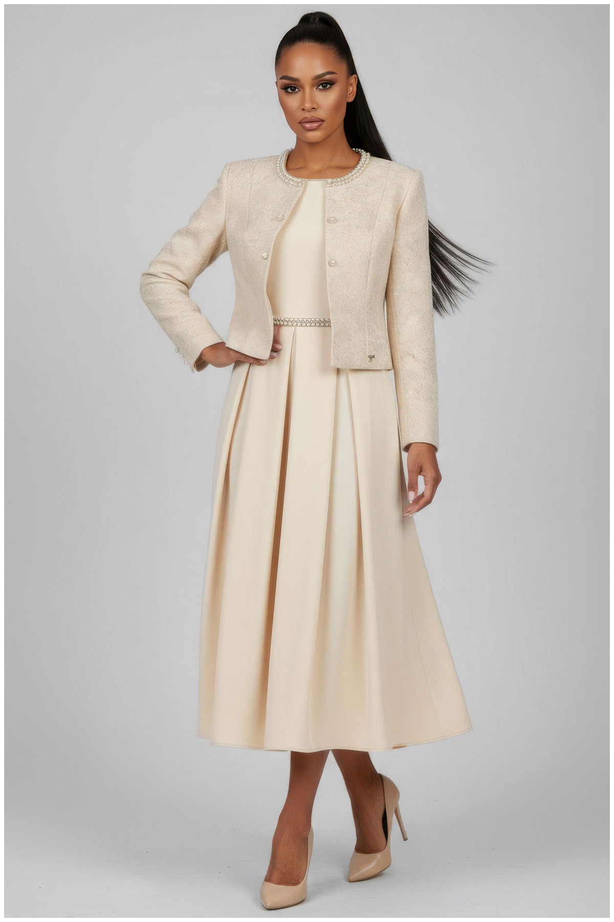 Woman wearing a beige suit with a jacket and skirt on a gray background