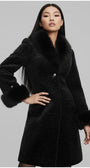 Woman wearing a black coat with fur trim on a gray background