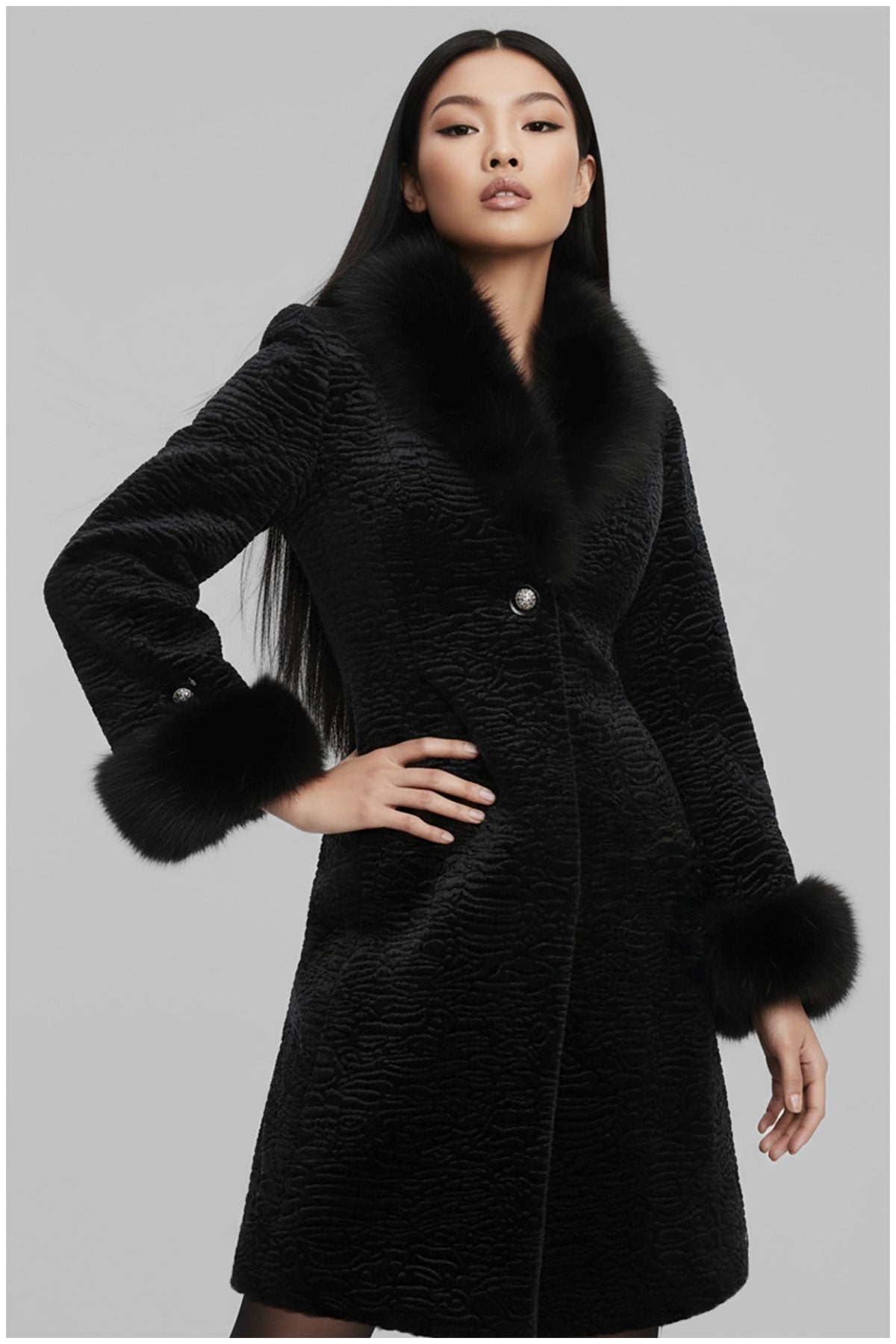 Woman wearing a black coat with fur trim on a gray background