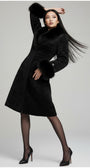 Woman wearing a black coat with fur trim on a white background