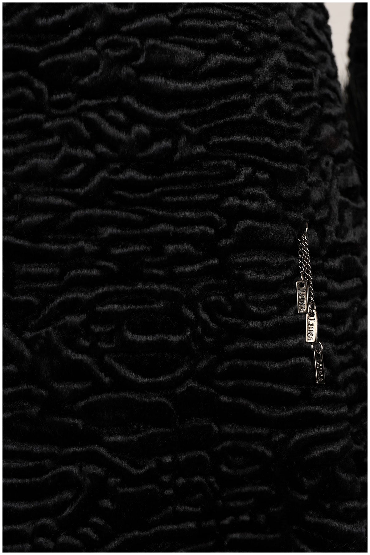 Close-up of a textured black fabric with a zipper detail.