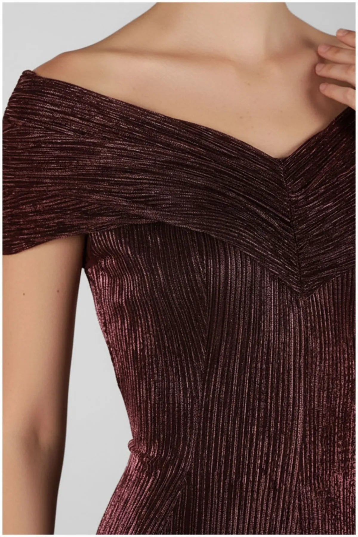 Close view of the bordeaux gown's folded off-shoulder neckline and fine vertical metallic texture