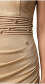 Close detail of the pearl-accented horizontal pleated waist band on the champagne gold cocktail dress