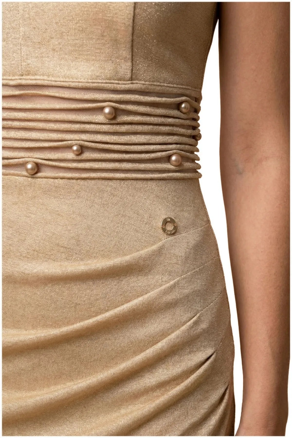 Close detail of the pearl-accented horizontal pleated waist band on the champagne gold cocktail dress