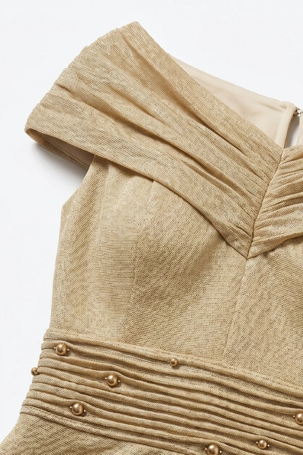 Detail of the champagne gold dress showing pleated off-shoulder neckline construction and shoulder-line draping