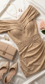 Champagne gold cocktail dress styled on ivory satin with nude pumps, neutral clutch, gold jewelry, and a pale rose