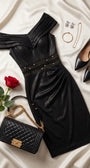 Anthracite cocktail dress styled with a black quilted handbag, pointed pumps, and gold jewelry on ivory satin.