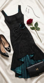 Black ruched satin evening dress styled with black pumps, clutch, silver jewelry, and red rose on ivory satin