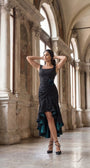 Model wearing black ruched satin high low evening dress in a grand historic interior with marble columns