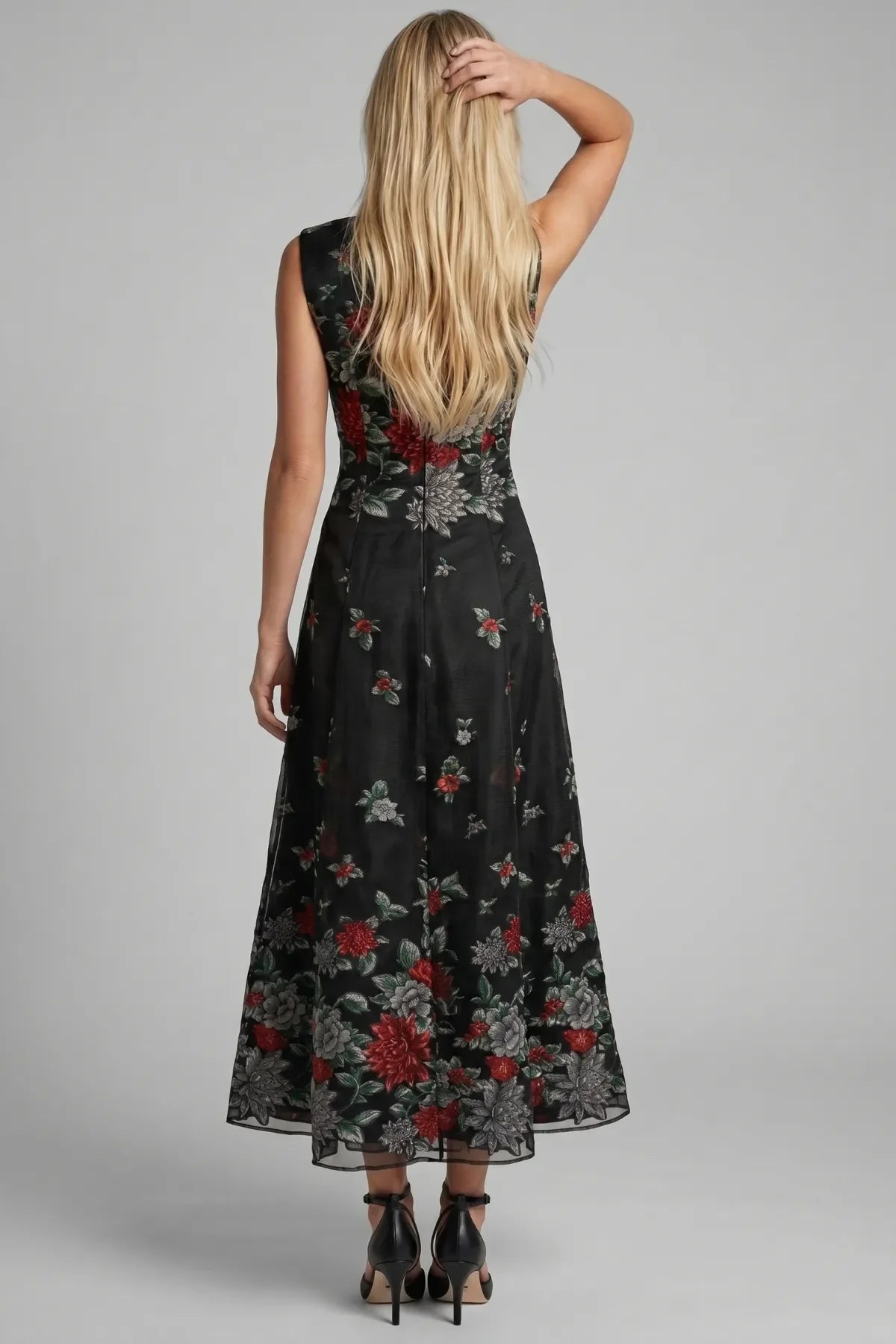 Back view of Rina black floral maxi dress with center zipper and floral hem placement.