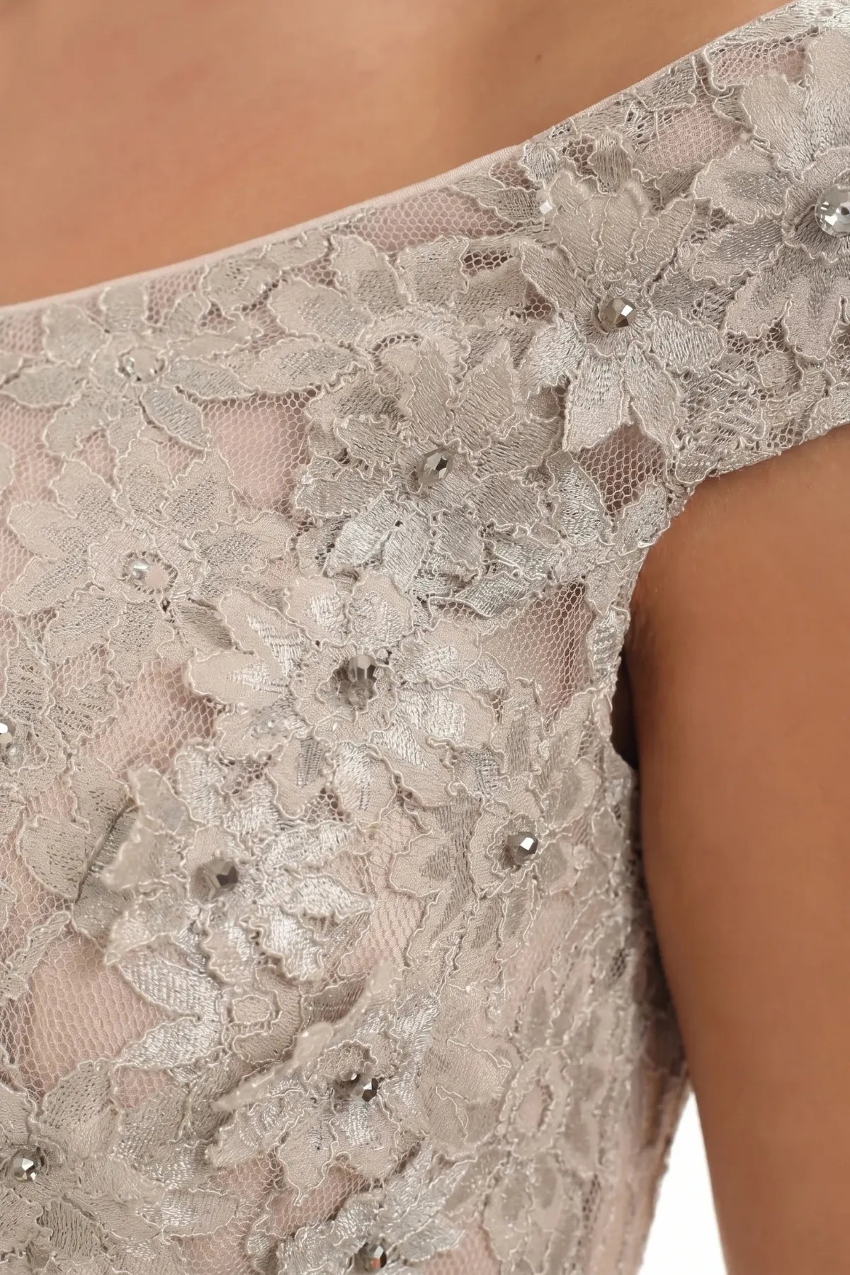 Bodice detail of the beige lace gown showing dimensional floral appliqué and crystal accents on the shoulder line