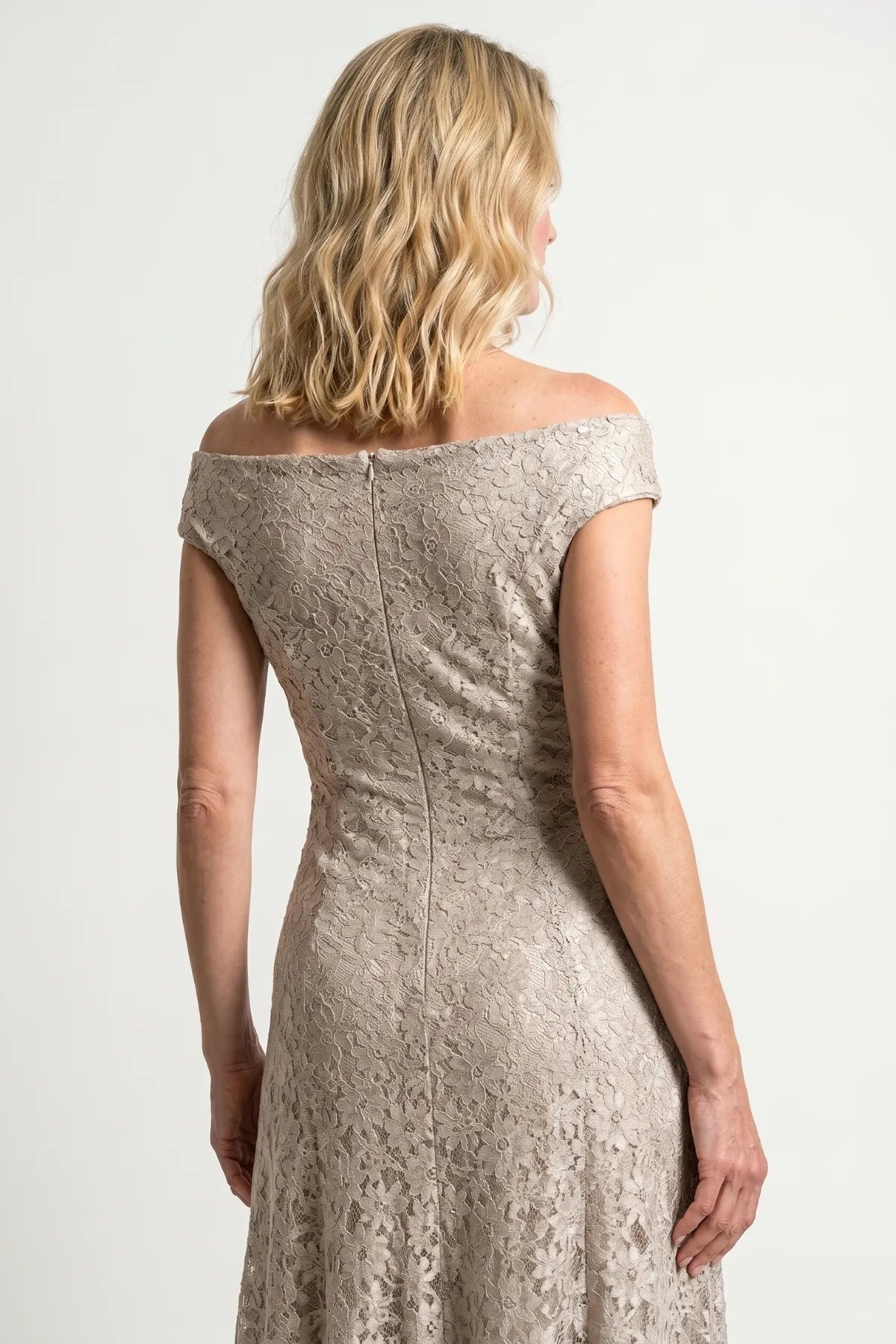 Closer back view of the beige lace gown showing shoulder line, zipper, and floral lace texture through the waist