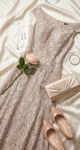 Beige lace gown styled on ivory satin with nude pumps, champagne clutch, silver jewelry, and a pale rose