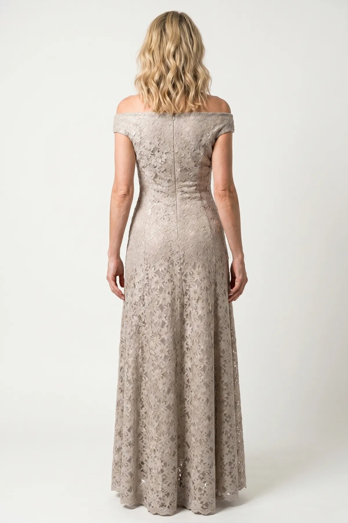 Back view of the beige lace gown showing the off-shoulder line, center back zipper, and softly flared skirt