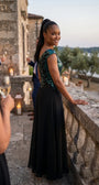 Side view of the Greta gown at a coastal evening reception with stone terrace and candles