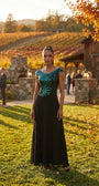 Greta teal and black evening gown shown full length at a fall vineyard celebration