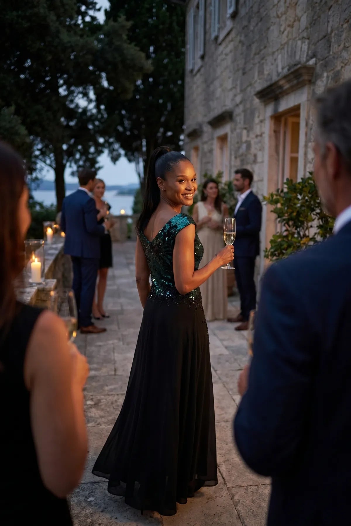 Teal and black Greta gown worn at an evening terrace celebration with candlelight