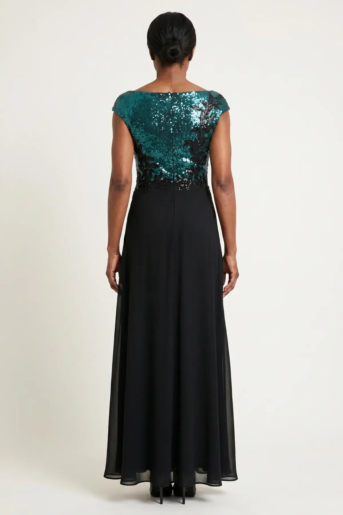 Back view showing the sequined bodice, center back zipper, and flowing black chiffon skirt