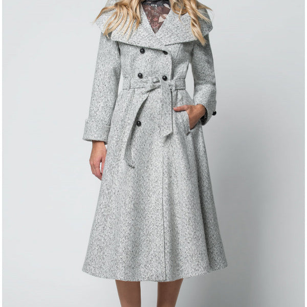 Woman wearing a long gray coat with a belt on a white background
