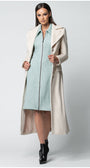 Woman wearing a long beige Luna Fashion House  coat over a light blue dress on a white background