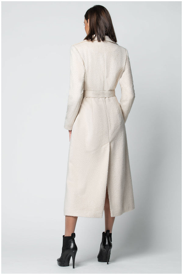 Woman wearing a long beige Luna Fashion House coat on a white background