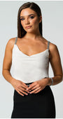 Woman wearing an white elegant blouse Dora with jeweled straps paired with a black skirt against a light background