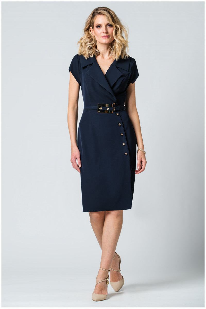 Woman wearing navy wrap dress with structured lapel, metallic buttons, wide belt, and pencil silhouette against white background