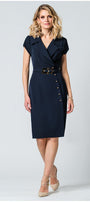 Woman wearing navy wrap dress with structured lapel, metallic buttons, wide belt, and pencil silhouette against white background