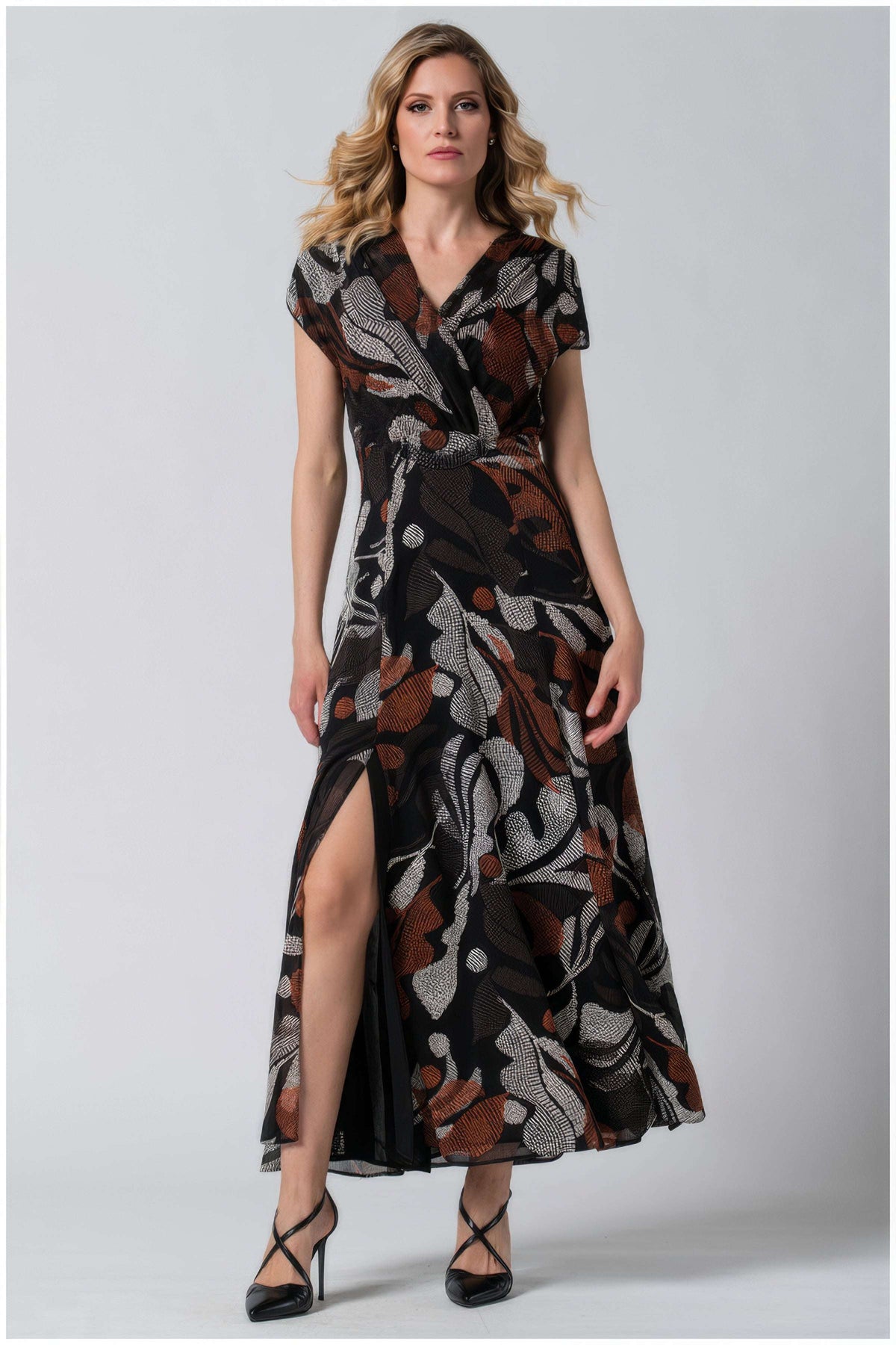 Floral Print Maxi Dress, Lola. Maxi dress. Black ground with a rust and cream abstract botanical print, surplice V-neckline, cap sleeves, gathered waist, and a front slit, on model.