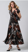 Woman wearing Long Dress Lola with bohemian print, flowing silhouette, and paired with black heels and handbag