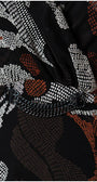 Close-up of black dress fabric with white and rust geometric patterns and decorative chain detail on Long Dress Lola.