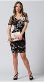 Woman wearing fitted short dress Lola with sheer sleeves, holding a matching handbag with flower brooch accessory