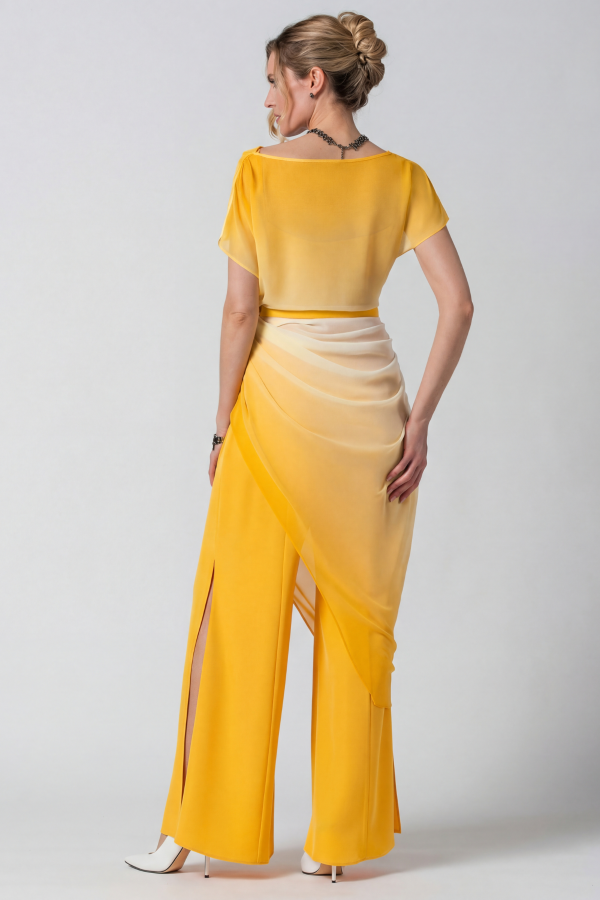 Woman wearing a yellow dress with a plain background