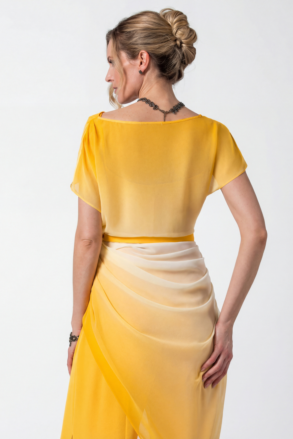 Woman wearing a yellow dress with a plain background