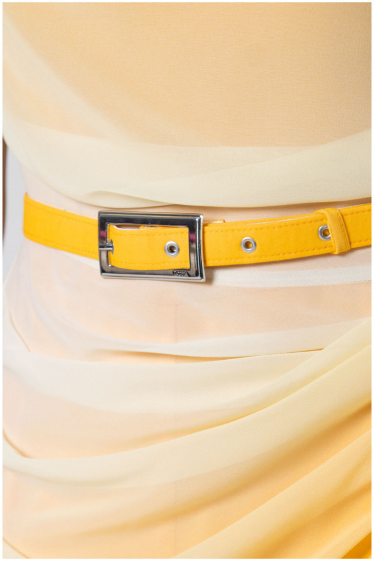 Yellow belt with a silver buckle on a light yellow dress