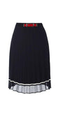 Navy blue pleated midi skirt with white trim and stretch waistband featuring a red decorative buckle, lightweight fabric.