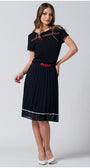 Woman wearing navy pleated midi skirt with white accents and a red buckle belt paired with black top and white heels
