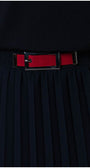 Close-up of navy pleated skirt with red stretch waistband and silver decorative buckle detail